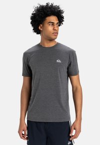 Donkergrijze T-shirt met korte mouwen van een zachte stof. Het heeft een klein wit logo op de linkerborst en een klassiek ronde halsontwerp.