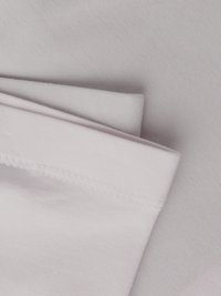 Δύο στοιβαγμένα κομμάτια υφάσματος: το ένα σε ανοιχτό γκρι και το άλλο σε απαλό ροζ. Και τα δύο έχουν ομαλή υφή και διακριτικό ράψιμο κατά μήκος των άκρων.