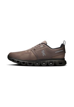 Chaussure de sport marron avec semelle noire, design segmenté rembourré et logo sur le côté, vue de l'extérieur.