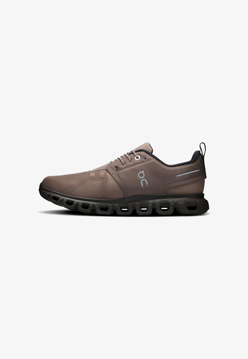 Chaussure de sport marron avec semelle noire, design segmenté rembourré et logo sur le côté, vue de l'extérieur.