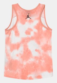 Tank top v broskvové a bílé batikové barvě s kulatým výstřihem, bez rukávů a černým logem Jordan na zadní straně. Materiál z bavlněné směsi.