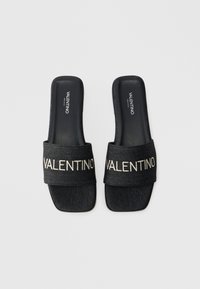 Riemensandalen mit einem strapazierfähigen dunkelblauen Denim-Riemen, der in Creme mit "VALENTINO" bestickt ist, flachen schwarzen Sohlen und quadratischem Zehendesign.