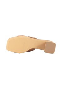 Sandal de tacón alto beige con un upper suave y una suela de goma texturizada con ranuras horizontales para mayor tracción.