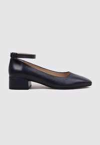 Zapatos de tacón bajo de cuero azul marino con punta afilada y correa en el tobillo. Textura suave y diseño de tacón grueso para mayor estabilidad.