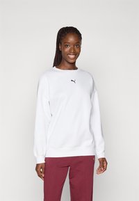 Sweatshirt alb cu guler rotund, având un mic logo Puma negru pe piept. Purtați cu pantaloni burgundi. Textură netedă și croială lejeră.