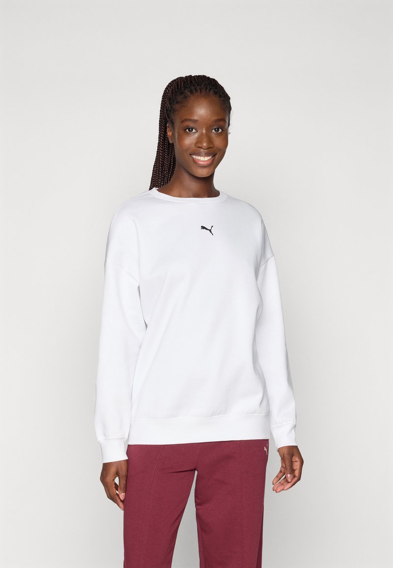 Sweatshirt alb cu guler rotund, având un mic logo Puma negru pe piept. Purtați cu pantaloni burgundi. Textură netedă și croială lejeră.