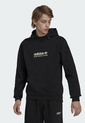 Felpa nera con cappuccio realizzata in materiale morbido, dotata di una tasca frontale, cappuccio regolabile e logo bianco con la scritta "adidas ADVENTURE".