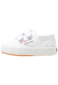 Sneakers in tela bianca con doppie cinghie in Velcro, suola in gomma testurizzata e dettagli logo di lato. Design leggero e slanciato.