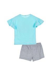 Top azul claro con mangas cortas con volantes combinado con pantalones cortos grises. Ambos hechos de tela suave, con un diseño casual y cómodo.