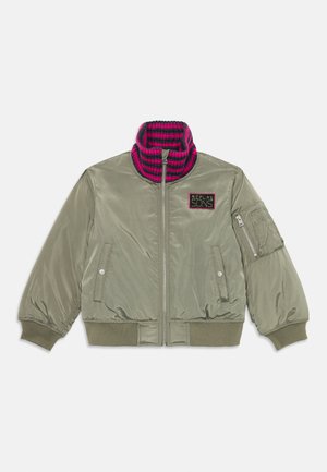 Olive green bomber jacket with a pink and navy striped ribbed collar, zip front, side pockets, and a patch detailing on the chest.