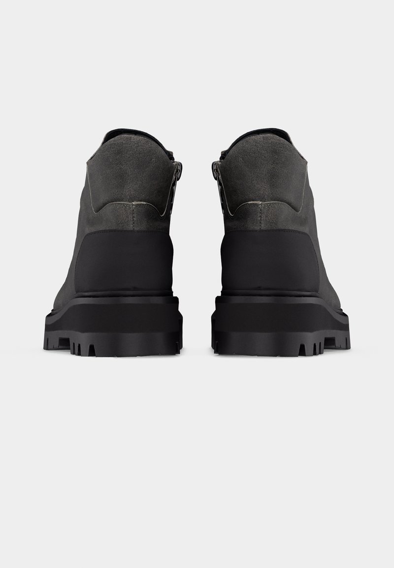 Pair of dark gray and black rugged boots shown from the back on a plain light background.