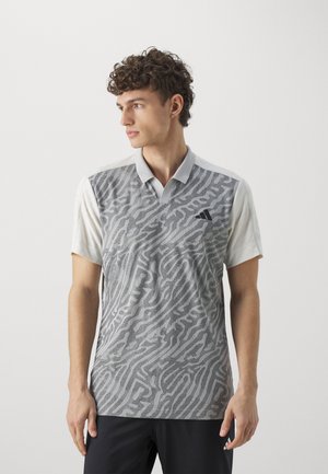 Polo gris avec un motif abstrait texturé ; manches courtes ; col boutonné ; logo Adidas sur la poitrine ; matériau léger.