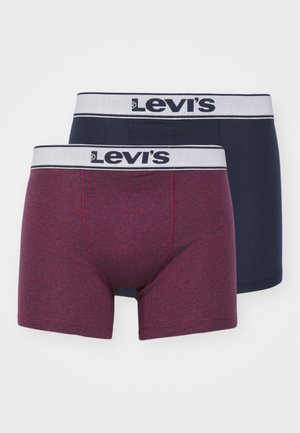 Du keturių Levi's bokserių poros: vieni tamsiai raudoni su heatheriniu tekstūru, kiti vientisi vandenynų mėlynumo. Kiekvieni turi baltą prekinio ženklo juostą.