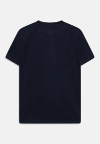 T-paita tummansinisestä kankaasta, jossa on lyhyet hihat, makaa tasaisena näyttäen selkäpuoleltaan. Kauluksen ja hihojen ympärillä näkyy selkeä ompelu.