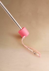 Metal cane with pink rubber tip and fabric wrist strap featuring cartoon design on beige background.