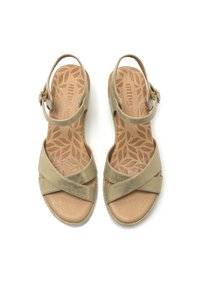Sandali beige con design a strap incrociato, caratterizzati da una finitura metallica testurizzata e una cinghia regolabile alla caviglia su un plantare ammortizzato.