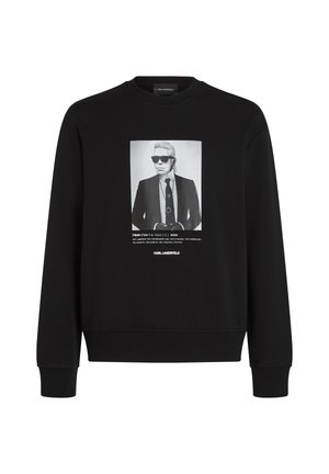 Crna pamučna majica dugih rukava s okruglim izrezom, s ispisanim monokromatskim portretom sprijeda i rebrastim manšetama i rubom.