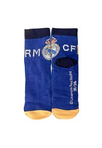 Calze di cotone blu con punta gialla, caratterizzate dal testo "RM" e "CF" e dal logo del Real Madrid. Texture a coste lungo la parte superiore. Taglia 31/34.