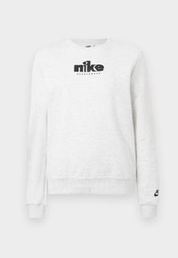 Λευκό μακρυμάνικο φούτερ Nike με μαύρο λογότυπο Nike Sportswear στο στήθος και μικρότερο λογότυπο στην μανσέτα του αριστερού μανικιού.