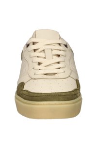 Weiße Sneaker mit grünen Wildlederakzenten, flachen Schnürsenkeln, perforierten Details und einer strukturierten Gummisohle für Grip und Langlebigkeit.