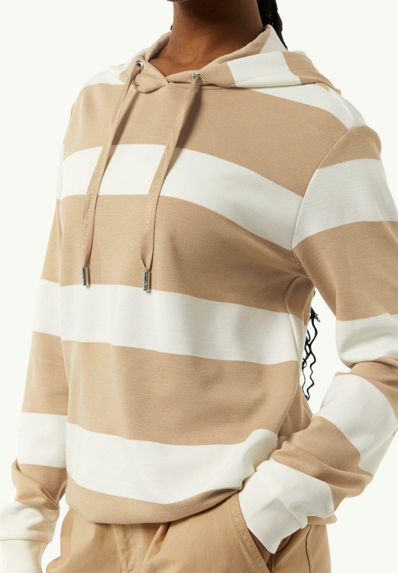 Sudadera a rayas beige y blanca con cordón, mangas largas, textura suave y un ajuste relajado. Diseño notable de rayas superpuestas.