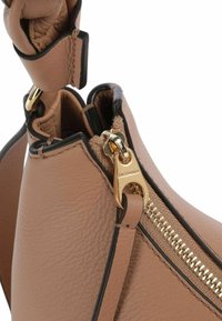 Borsa a mano in pelle marrone con cerniera dorata e bordo nero a contrasto, dotata di una superficie testurizzata e dettaglio con manico ad anello.