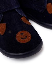Scarpe per bambini in suede blu con accenti in suede marrone, caratterizzate da un design con faccia di orso e orecchie modellate, fissate con una striscia in velcro.
