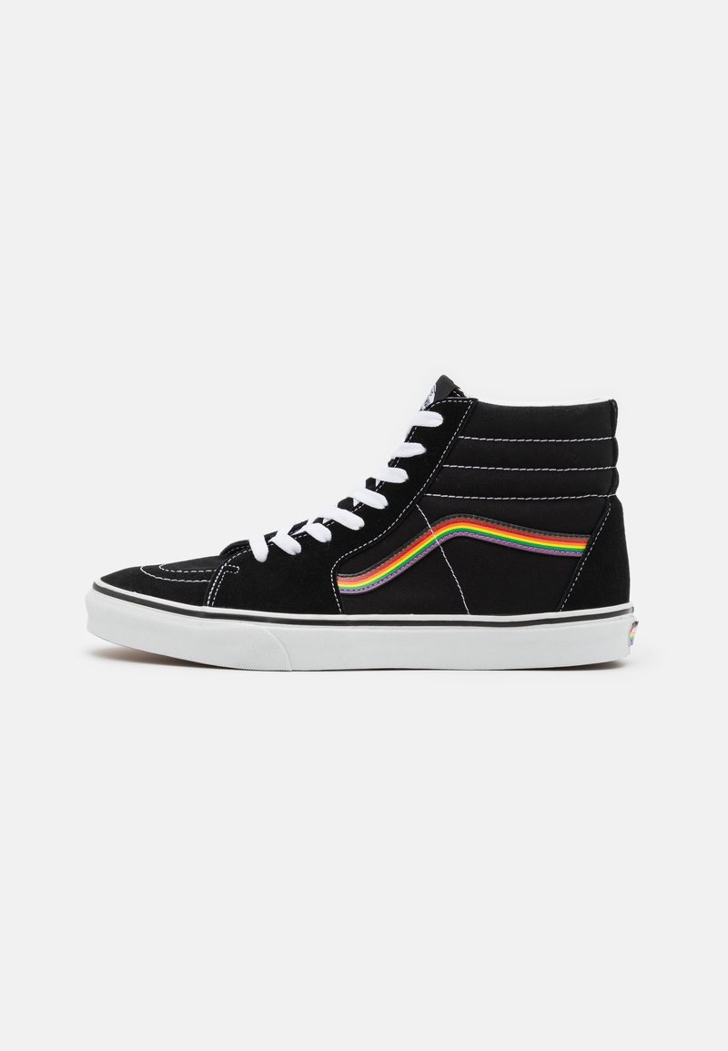 Baskets montantes noires avec lacets blancs, semelle blanche et une bande arc-en-ciel sur le côté sur un fond uni.