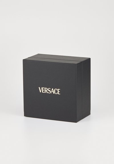 Mustaline musta ristkülikukujuline kast, millel on tekstureeritud pind ja keskosas kuldne "VERSACE" logo.