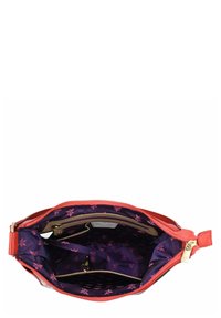 Rote Lederhandtasche mit einem Reißverschluss oben, ausgestattet mit einem lila blütenmusternden Innenfutter, mehreren Fächern und einem Reißverschlussgriff in goldfarbener Ausführung.