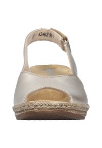 Sandale en cuir doré avec un bout ouvert et une bride de cheville. Dispose d'une semelle intérieure rembourrée et d'une semelle texturée avec des détails ressemblant à du jute.