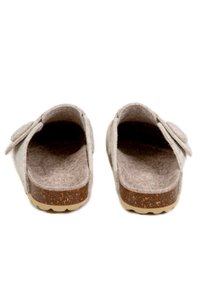 Sabots gris en feutre avec une semelle intérieure en liège en forme anatomique. Design à l'arrière ouvert, bout rond, et un accent en forme de fleur sur le côté. Semelle texturée.