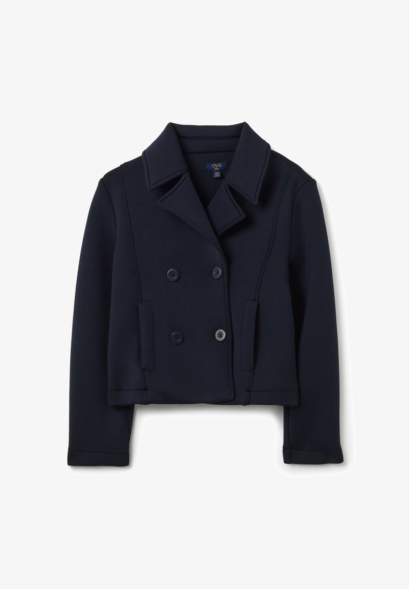 Chaqueta azul marino cruzada hecha de tela suave. Presenta mangas largas, cuello con solapa y dos bolsillos delanteros con botones.