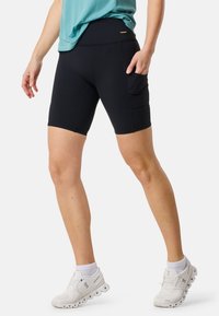 Pantaloni corti sportivi neri con vita alta, dotati di una tasca laterale. Il tessuto è liscio e leggermente elasticizzato, adatto per l'attività fisica.