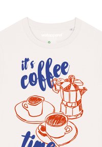 Ecrufarbenes T-Shirt mit einem blauen und orangefarbenen Grafikdesign von Kaffeetassen und einer Moka-Kanne, versehen mit dem Text "Es ist Kaffeezeit."