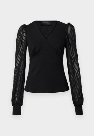 Schwarzes Oberteil mit V-Ausschnitt und figurbetontem Oberkörper, ausgestattet mit transparenten, strukturierten langen Ärmeln und geknöpften Enden. Glatter Stoff mit rüschendetaillierten Akzenten.