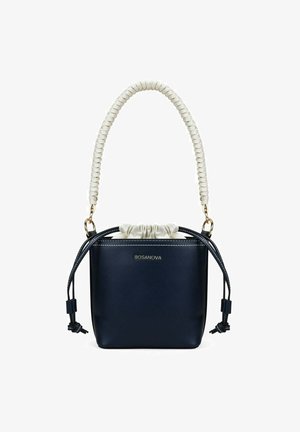 Bolso estilo cubo azul marino con asa trenzada blanca, cierre de cordón y herrajes dorados, con la marca BOSANOVA en el frontal.