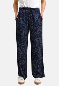 Navy blue wide-leg pants in lightweight fabric with white abstract leaf patterns, featuring an elastic waistband and side pockets.