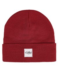 Rote Strickmütze aus weichem Material. Mit umgeschlagenem Bund, auf dem ein weißes Label mit schwarzem Markenlogo angebracht ist. Texturiertes Rippenmuster.