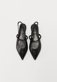 Chaussures slingback en cuir noir avec des bouts pointus, des fines bretelles et des accents tressés. Texture lisse avec un petit talon et une semelle intérieure rembourrée.