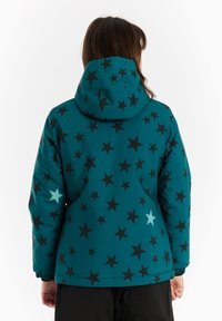 Teal pufasta jakna s kapuljačom koja ima uzorak zvijezda u crnoj boji, s naglaskom na svijetloplavoj zvijezdi. Elastične manžete i glatka tekstura.