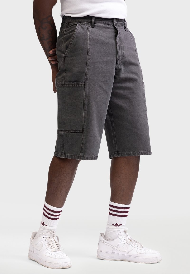 Grå cargoshorts med sidelommer, afslappet pasform, knælængde og syede detaljer. Sæt sammen med hvide sneakers og stribede sokker.