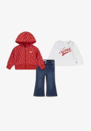 Hoodie rouge zippé avec motif floral, haut blanc à manches longues avec le logo "Levi's" et pantalons en denim foncé évasés.