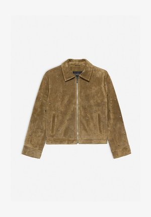 Bruine suède jas met een kraag, ritssluiting aan de voorkant en decoratieve zilveren studs op het lichaam. Voorzien van twee zijzakken.