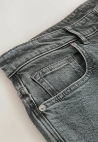 Grå denimjeans med smal passform, med en frampocket, subtil sömnad och en metalldetalj på midjebandet.