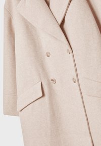 Cappotto di lana beige doppio petto con ampi rever, quattro bottoni e tasche a patta su entrambi i lati.