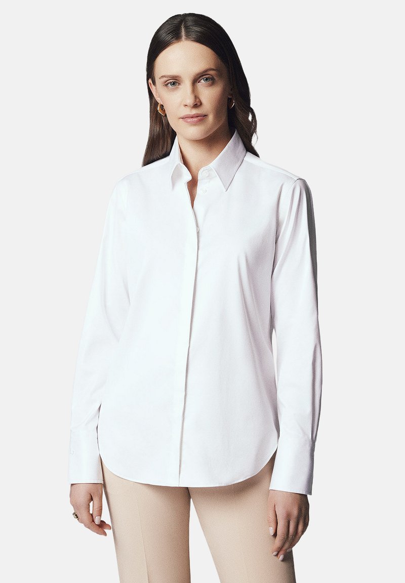 Biała koszula z guzikiem, z klasycznym kołnierzykiem, długimi rękawami i lekko zaokrąglonym dołem. Wykonana z gładkiego materiału o wyrazistym wykończeniu.