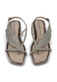 Sandali in argento con decorazioni, dotati di suola piatta e un design a forma di foglia, con numerosi strass lungo le cinghie.