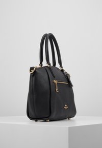 Borsa a tracolla in pelle nera con finitura testurizzata, accessori in metallo dorato, due manici e una tasca esterna con zip. Presenta un emblema del marchio sul fronte.