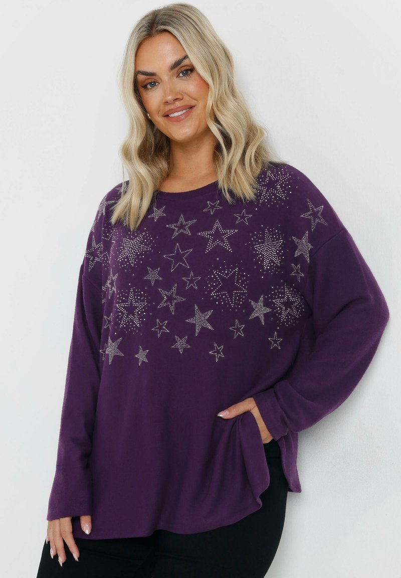 Pull violet à manches longues avec des accents d'étoiles métalliques et une coupe décontractée. Tissu doux, encolure arrondie et poches latérales.